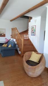 a living room with a chair and a wooden staircase at Villa da Praia Azul in Silveira