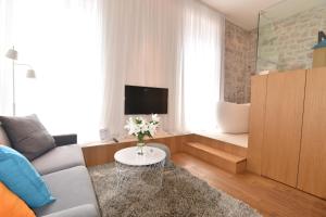sala de estar con sofá y mesa con flores en The Bridge Luxury Apartments, en Zadar