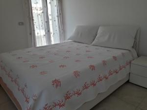 アルバタックスにあるCasa Lisa a Porto Frailisの白い毛布と赤い花のベッド