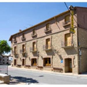 Larraga的住宿－Hostal Casa Perico，街道边的一座大型石头建筑