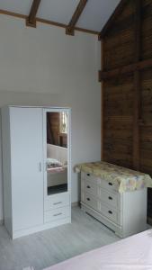 a bedroom with a bed and a dresser and a mirror at Les Alizés du Nord in Anse-Bertrand