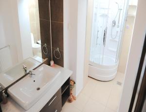 a white bathroom with a sink and a shower at Royal Grand Suite in Cluj-Napoca