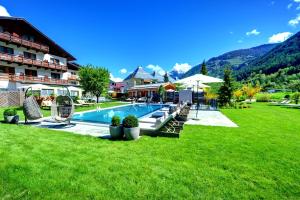 a hotel with a swimming pool in a field of grass at Hundehotel Riederhof in Ried im Oberinntal