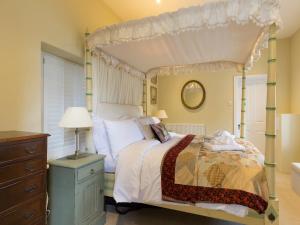 ein Schlafzimmer mit einem Himmelbett und einer Kommode in der Unterkunft Castle Gatehouse in Winchcombe