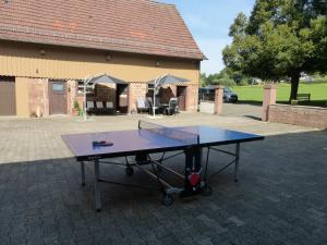 a ping pong table in front of a building at Ferienwohnungen Zur Mühle in Mossautal