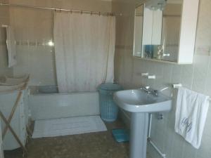 a bathroom with a sink and a tub and a toilet and a sink at Apartamento Rosa in Vila Nova de Milfontes +23 photos