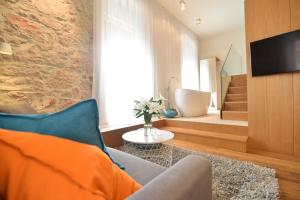 sala de estar con sofá, TV y bañera en The Bridge Luxury Apartments, en Zadar