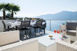 a table and chairs on a balcony with a view of the water at Villa Poseidon in Porto Valtravaglia