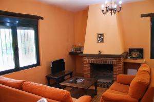 - un salon avec un canapé et une cheminée dans l'établissement Casa Rural Molino de la Máquina, à Cartajima