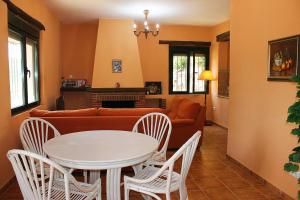 - un salon avec une table, des chaises et un canapé dans l'établissement Casa Rural Molino de la Máquina, à Cartajima