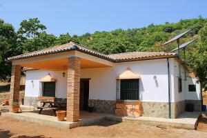 ein kleines weißes Haus mit einem Tisch davor in der Unterkunft Casa Rural Molino de la Máquina in Cartajima