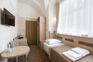 een hotelkamer met een bed, een tafel en een raam bij Długi Dom in Jelenia Góra