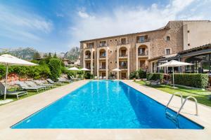 a swimming pool in front of a building at Hotel Ca'l Bisbe in S&oacute;ller