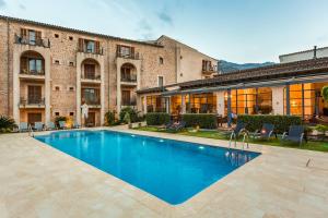a swimming pool in front of a building at Hotel Ca'l Bisbe in Sóller