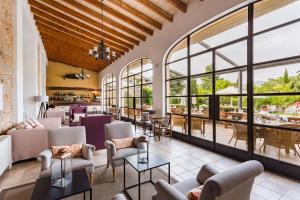a lobby with couches and tables and windows at Hotel Ca'l Bisbe in Sóller