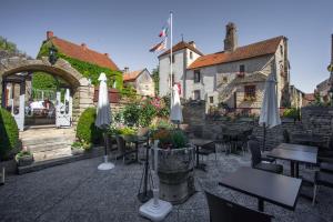 a restaurant with tables and umbrellas in front of a building at Hostellerie Du Chateau in Châteauneuf