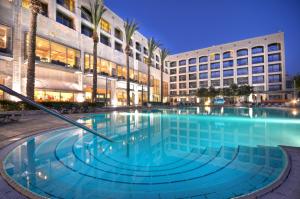 a large swimming pool in front of a building at Golden Crown Hotel in Nazareth