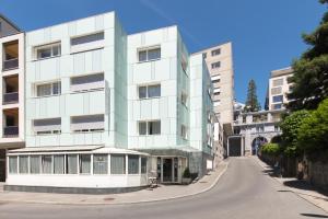 a tall white building on a street with buildings at Bon Port in Montreux