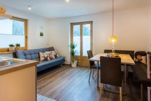 a living room with a blue couch and a table at Alpen Appartement BelEtage in Mayrhofen