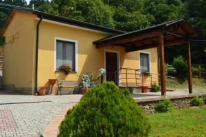 mały żółty dom z gankiem i ławką w obiekcie Agriturismo E Turre w mieście Serrastretta