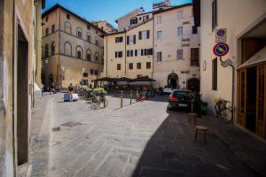 eine Stadtstraße mit Gebäuden und Menschen auf Fahrrädern in der Unterkunft Casa Laura in Florenz