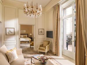 a living room with a chandelier and a bedroom at Shangri-La Paris in Paris