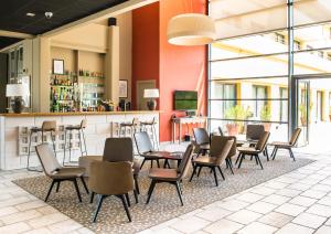 アヴィニョンにあるアヴィニョン グラン ホテルのテーブルと椅子のあるレストラン、バー