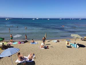 a beach filled with people and umbrellas on a sunny day at Hotel Vittorio in Portopalo