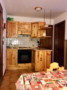 una cucina con armadi in legno e piano cottura. di Appartamento in residence: sulle piste da sci a Passo del Tonale