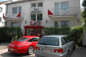 deux voitures garées devant un bâtiment dans l'établissement Hotel Roemerstein, à Mayence