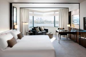 a hotel room with a large bed and a desk at Crown Metropol Perth in Perth