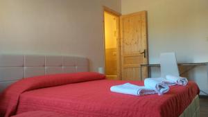 サッサリにあるBed & Breakfast La Landriggaのベッドルーム1室(赤いベッド1台、タオル付)