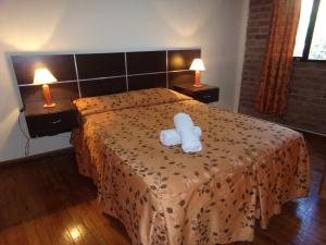 a hotel room with a bed with a white towel on it at Cabañas El Challao in Mendoza