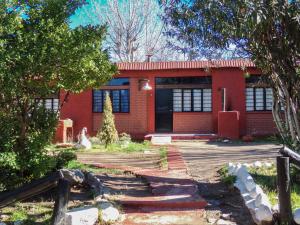dom z czerwonej cegły z płotem przed nim w obiekcie Cabañas El Challao w mieście Mendoza