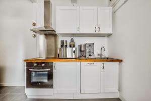 a kitchen with white cabinets and a stove at Le Petit Pavillon de Versailles in Versailles +6 photos