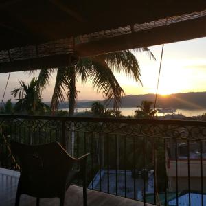 einen Balkon mit einem Stuhl und Meerblick in der Unterkunft Ocean Terrace in Port Blair