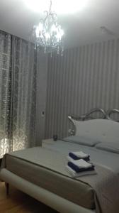 クロトーネにあるDonna Margharetのベッドルーム(シャンデリア付きの白い大型ベッド1台付)