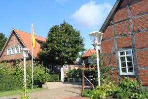 Landesbergen的住宿－蘭德斯貝爾根磨坊賓館，砖砌的建筑,有旗帜和街灯