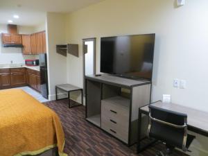 a room with a bed and a flat screen tv at Scottish Inn and Suites in Katy