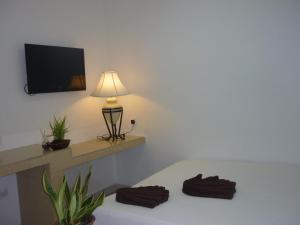 a room with a bed with a lamp and a tv at Hotel Paka INN in Paka