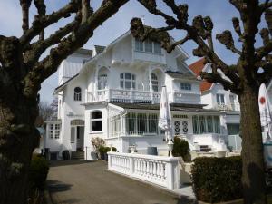 a large white house with a white balcony at Villa WellenRausch - Adults Only in Travemünde