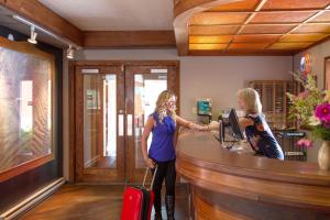 two women standing at a counter with luggage at The Lodge at Arrow Lakes in Nakusp