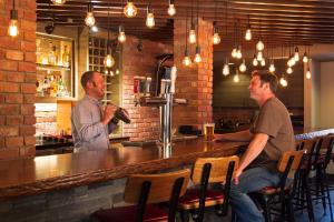 two men sitting at a bar in a restaurant at The Lodge at Arrow Lakes in Nakusp