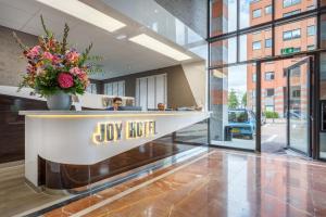 a lobby with a desk with a vase of flowers at Joy Hotel in Amsterdam