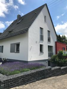 a white house with purple flowers in front of it at Wander- und Aktivchalet in Birkenfeld