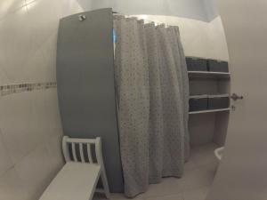 a bathroom with a shower curtain and a chair at Aire Marino in Balneario Claromecó +23 photos