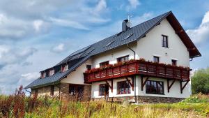 una grande casa bianca con il tetto nero di Apartmány Chajdovka a Boží Dar