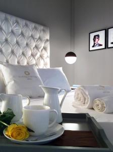 a tray with cups and saucers on a bed at CinqueSuites Ortigia in Syracuse +36 photos