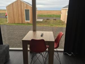una mesa y dos sillas frente a una ventana en Welcome Holiday Home, en Eyvindarhólar