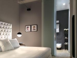 a bedroom with a bed and a bathroom with a sink at CinqueSuites Ortigia in Siracusa +36 photos